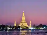 Wat Arun bei Abendbeleuchtung am Chao Phraya in Bangkok